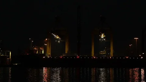 Container Cargo freight ship with working crane bridge in shipyard at night Stock Footage 116653696