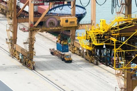 Container Cargo freight ship with working crane loading bridge in shipyard at Stock Photos