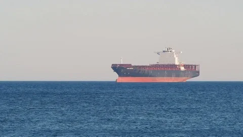 Container  cargo ship anchored off the harbor awaiting  loading Stock Footage 77777506