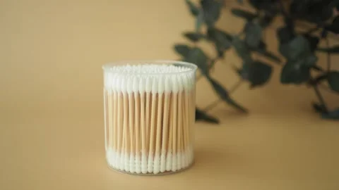 Container of cotton swabs on a plain background Stock Footage 340303927