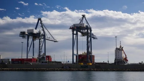 Container cranes unloading a ship at the industrial port of Alicante, Spain. Stock Footage 332662647