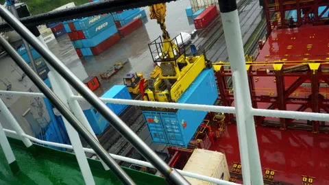 Container descends from crane swaying gently above ship deck Stock Footage 318953715