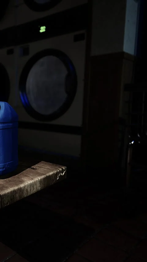 Container of detergent on a wooden table in a laundry room during evening hours Stock Footage 342174807