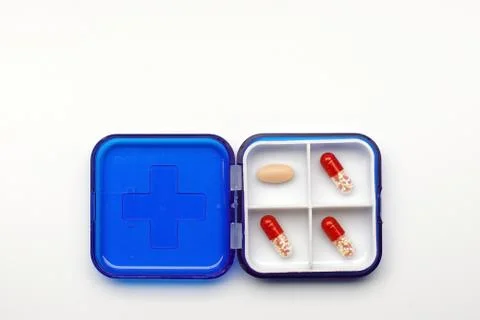 Container with different capsules and tablets on a white background, concept Stock Photos