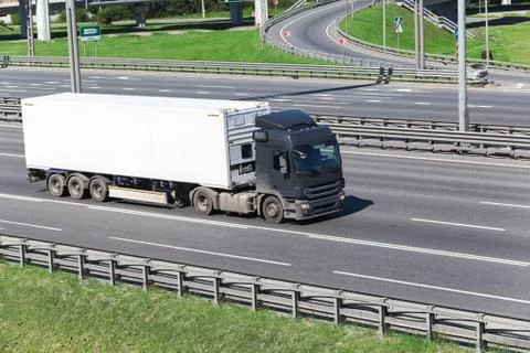 Container driving on the highway with white refrigerator semitrailer Stock Photos