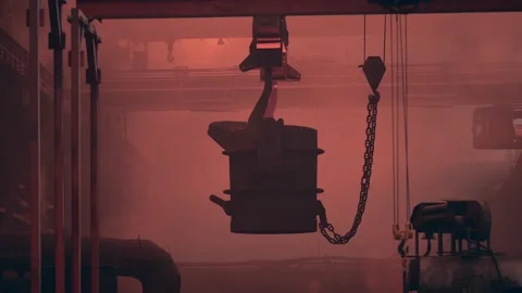 Container filled with liquid iron in blast furnace on crane moves through Stock Footage 153401581