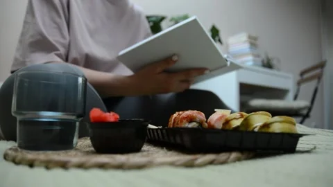 A container filled with sushi rolls is shown in the foreground Stock-Footage 347155589