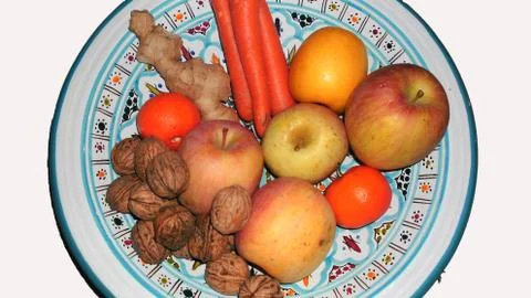 Container with fruit, vegetables, ginger and nuts. Stock Photos