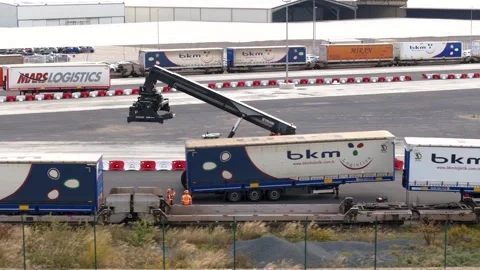 Container Handler Loading Semi-Trailer onto Freight Train at Le Havre Logistics Stock Footage 337976505