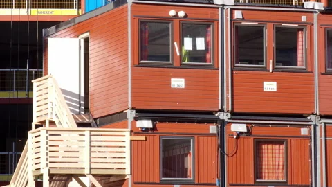 Container homes and offices on a construction site - red shipping containers Stock Footage 232093015