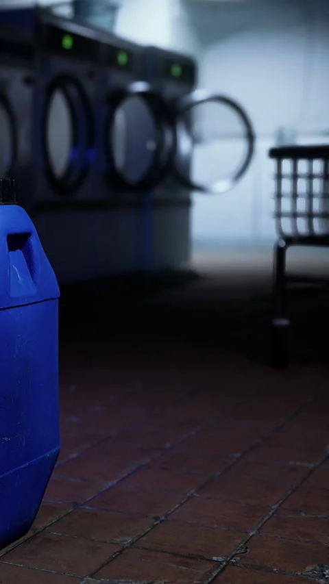 Container in a laundry area with washing machines and a cart nearby Stock Footage 340648901