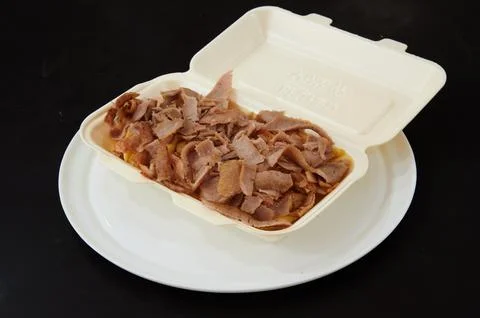 A container of meat is on a plate Stock Photos