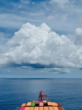 Container Ship Bow Beneath Towering Tropical Cumulus Cloud Stock Photos