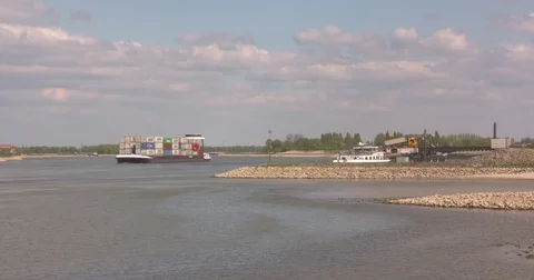 Container ship downstream river Waal, sand dumper unloads at riverside Stock Footage 75410121