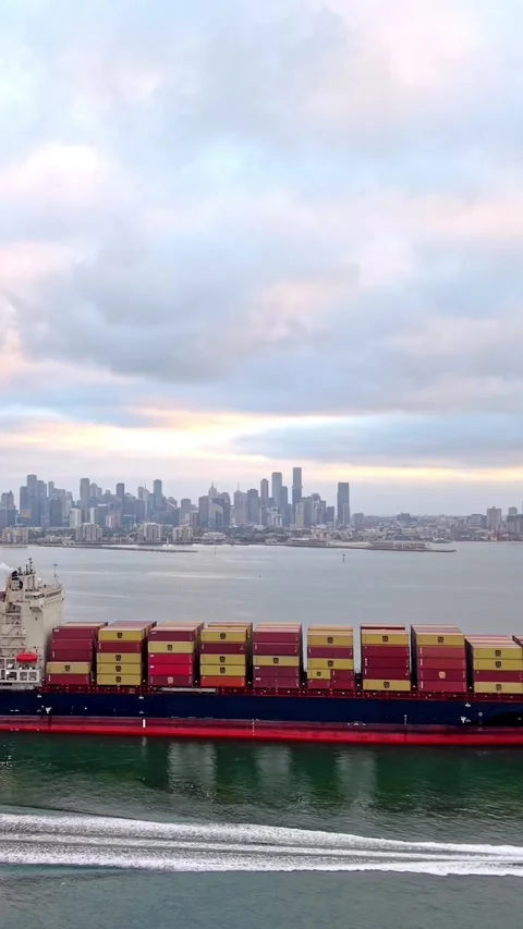 Container ship entering Port of Melbourne with city skyline 動画素材 332778466