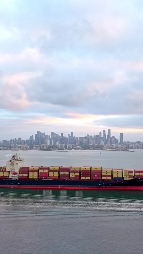 Container ship entering Port of Melbourne with city skyline Vídeo Stock 332778515