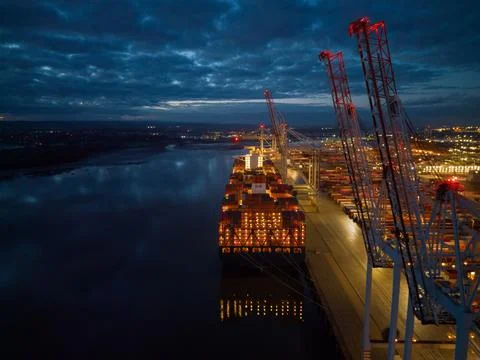 Container ship lights at dusk with crane at Southampton Docks UK aerial Stock Photos