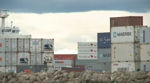 Container ship moves past stacked containers Stock Footage 537596