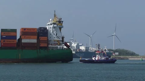 Container ship navigates inbound + tug assist, GATE gas terminal in background Stock Footage 53608642