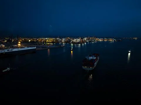 Container Ship Navigating Industrial Port Terminal At Night High Angle Shot Fotos de archivo