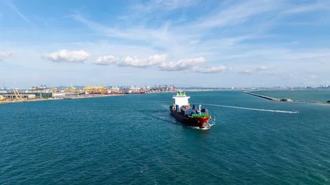 Container Ship Navigating Toward Busy Industrial Harbor In Chon Buri Thaila.. Stock Photos