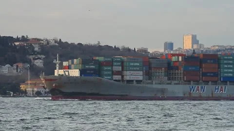 Container ship sails past the city skyline Stock Footage