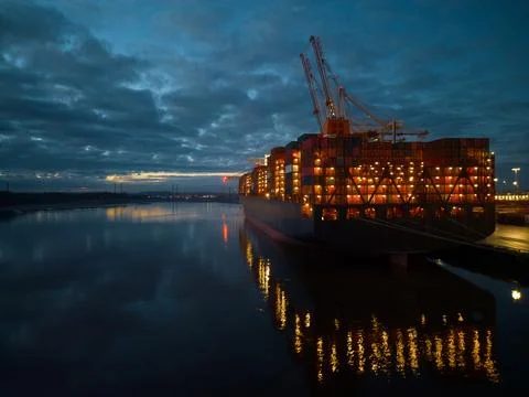 Container ship stern with lights at dusk Southampton Docks UK aerial closeup Stock Photos