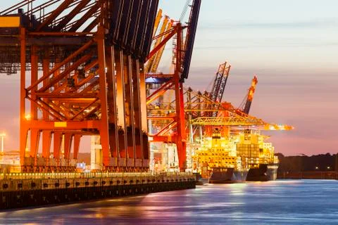 Container ship at a terminal at dusk Stock Photos