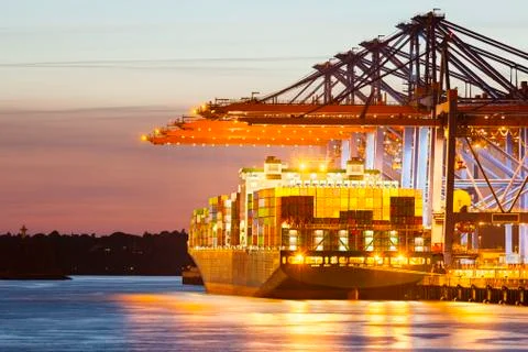 Container ship at a terminal at dusk Stock Photos