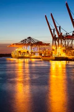 Container ship at a terminal at dusk Stock Photos