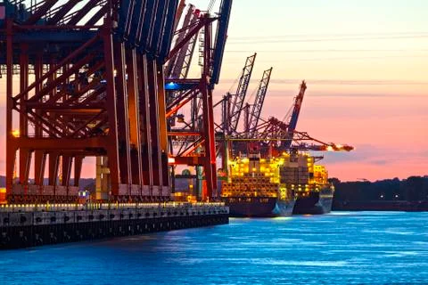 Container ship at a terminal at dusk Stock Photos