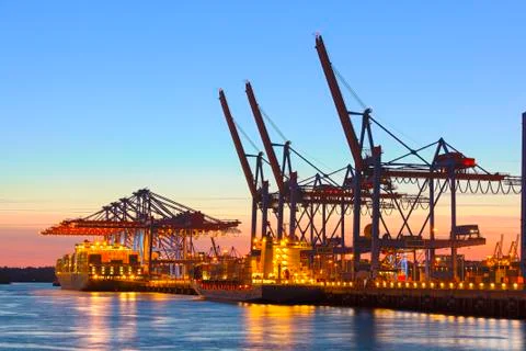 Container ship at a terminal at dusk Stock Photos