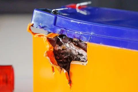 Container shows damage from sharp object near colorful box Stock Photos