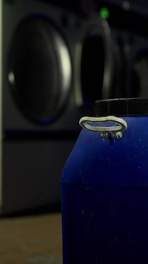 Container sits in laundry room near washing machine during evening hours Stock Footage 342446957