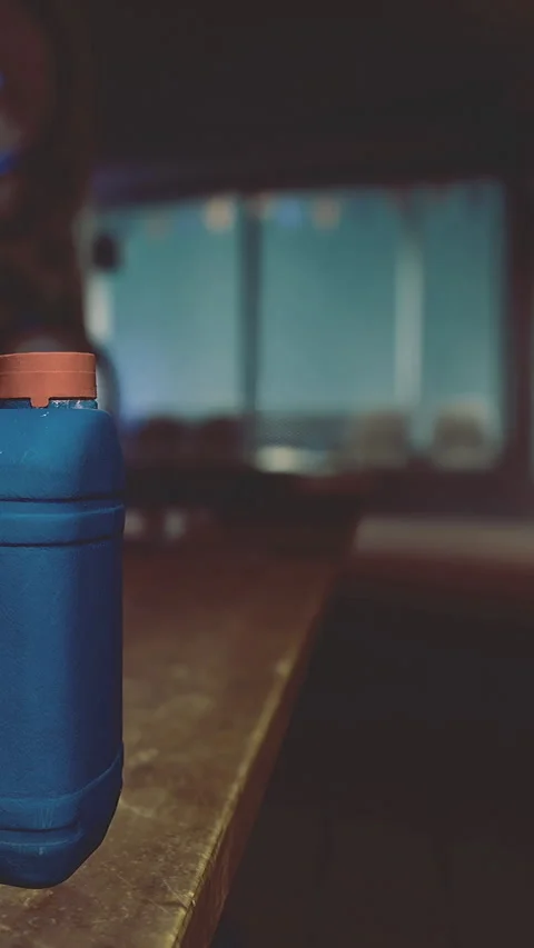 Container sits on a table with a blurred background in a dimly lit room Stock Footage 331682395