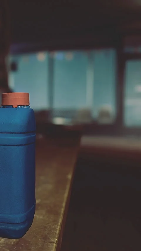 Container sits on a table with a blurred background in a dimly lit room 動画素材 335449755