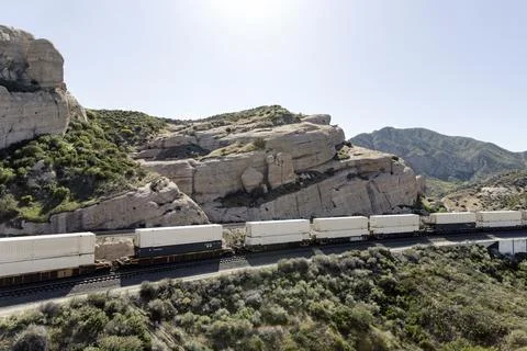 Container stack train in rocky landscape environment Stock Photos