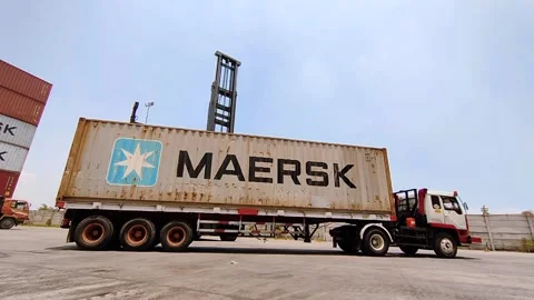 A container stacker moves a "Maersk" container high above ground level Stock Footage 312021784