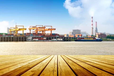 Container stacks and ship under crane bridge Stock Photos