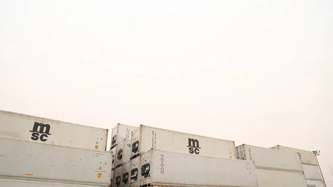 Container stacks in a storage yard during a cloudy afternoon in a busy port Vídeo Stock 318187731