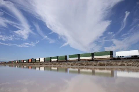 Container stacks on a train reflected in water Stockfoto's