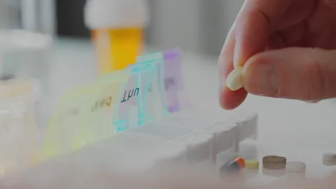 Container for tablets. A man with health problems slowly sorts medical suppl Video stock 259708372
