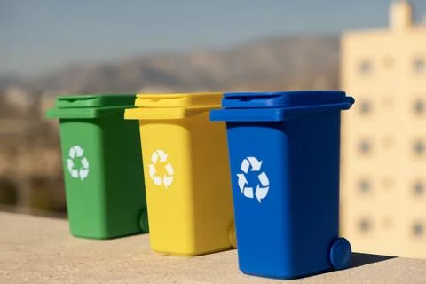 Container trash bin for recycling with city background. Green, yellow, blue.. Stock Photos