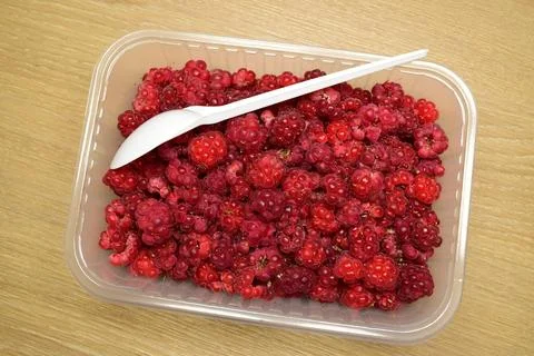 Container of unwashed fresh raspberries Stock Photos