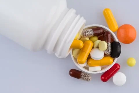 Container with various scattered pills Foto stock