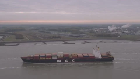 A container vessel passing by a Dutch harbor Stock Footage 220343893