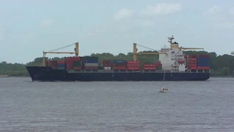 Container vessel on river Elbe + small white sailing yacht in front (sails down) Stock Footage 143962721