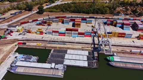 Container yard and barge terminal near a river in a busy logistics area Видео 343118449