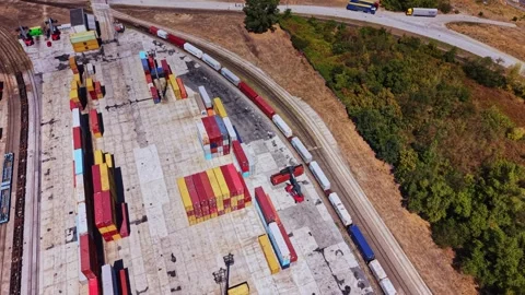 Container yard with trucks and cargo near railway tracks Stock Footage 343118609