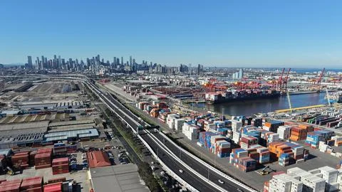 Container yards and cargo terminals with Melbourne CBD skyline. Stock Photos